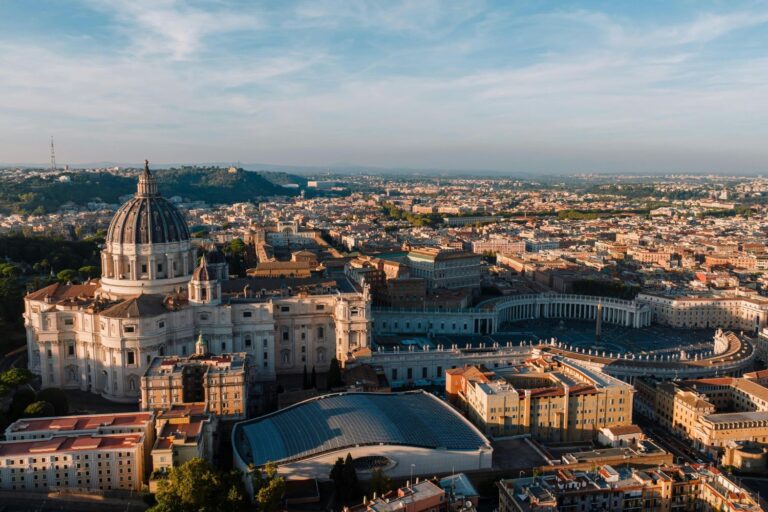 A breathtaking aerial view of St. Peter’s Basilica and St. Peter’s Square in Vatican City at sunrise, showcasing the grandeur of this iconic religious and historical site