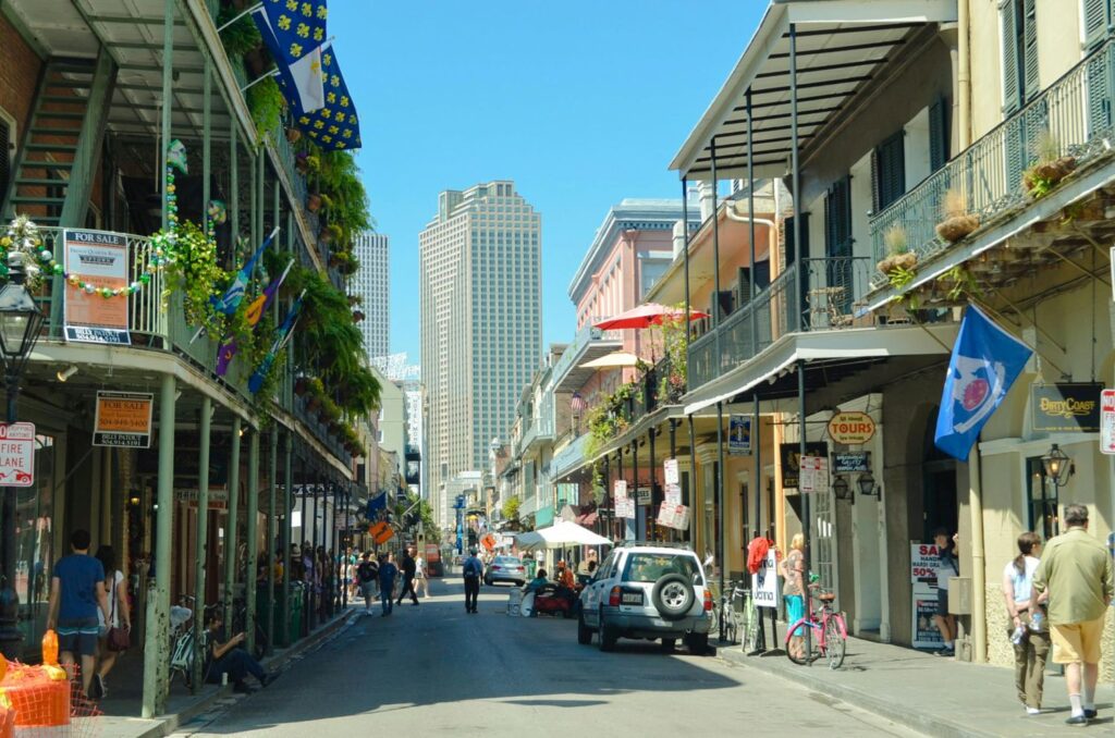 USA Travel, Colorful street in the French Quarter of New Orleans with historic buildings, flags, and people walking