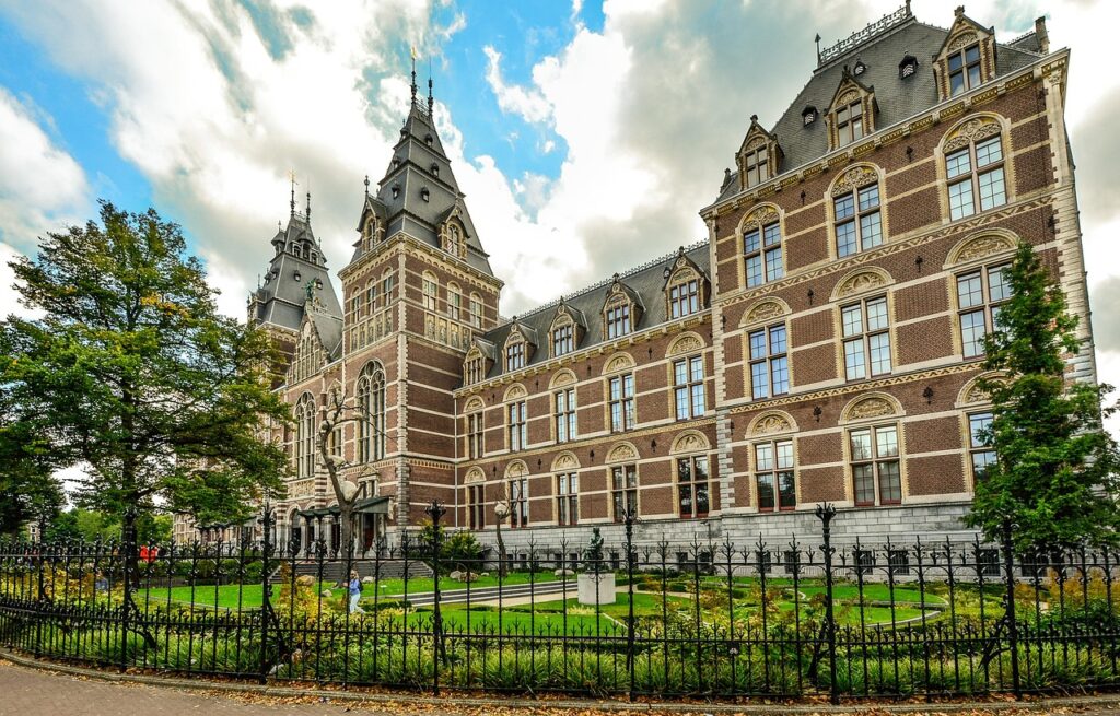 Exterior view of the Rijksmuseum in Amsterdam with Gothic-Amsterdam Travel Guide Renaissance architecture and landscaped garden.