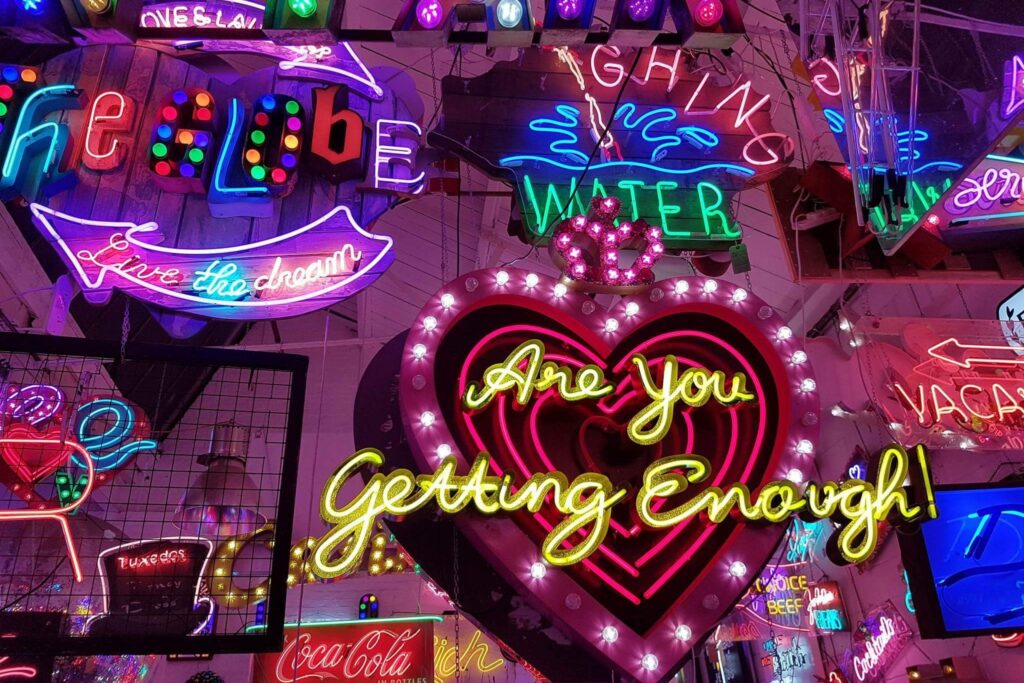 Interior of God’s Own Junkyard in Walthamstow – an offbeat thing to do in London for curious travellers, featuring neon signs and vintage light art.