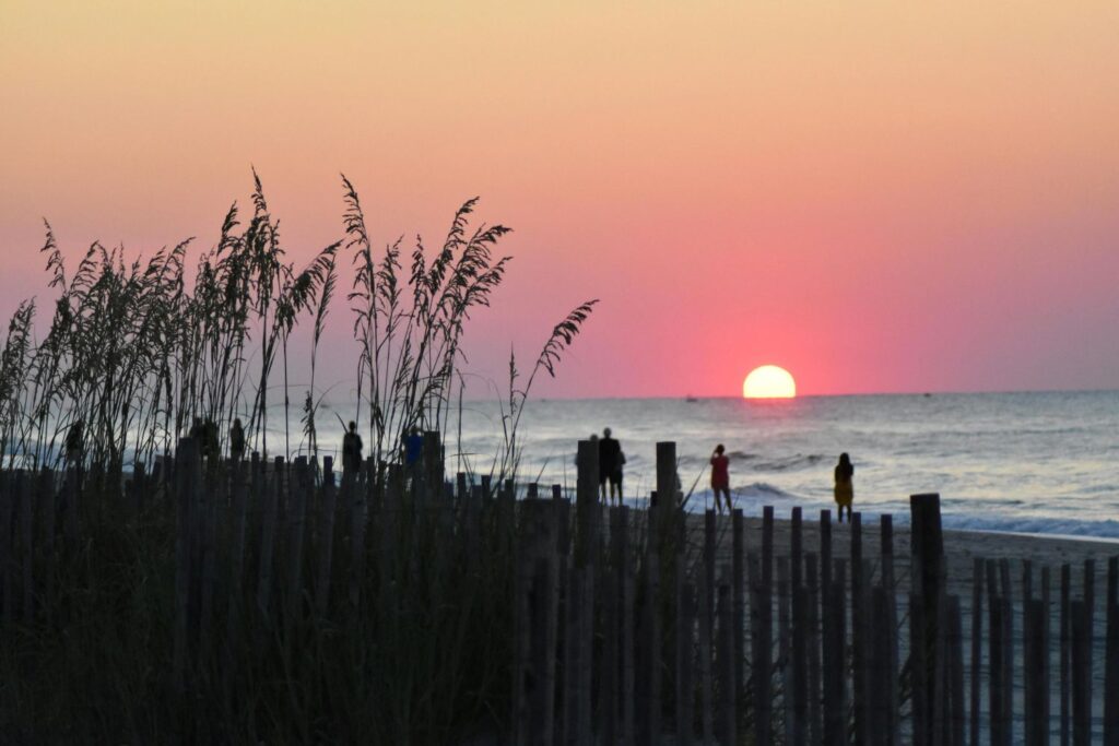 Sunrise over Myrtle Beach, South Carolina, with sea oats and early beachgoers — capturing one of the best beach vacations USA summer 2025.