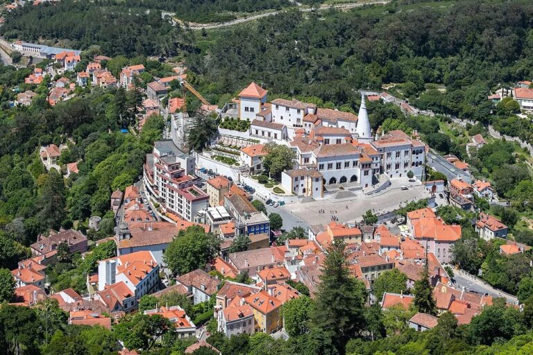 Aerial view of the white Sintra National Palace and red-roofed buildings in central Sintra, Portugal.