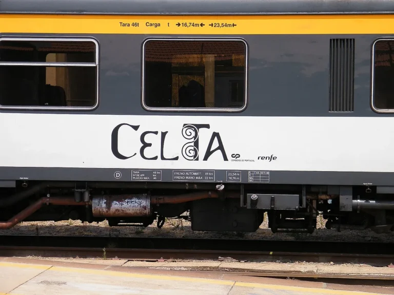 Side view of the Celta international train carriage showing the black stylized Celta logo with the CP and Renfe operator emblems on a white background panel.